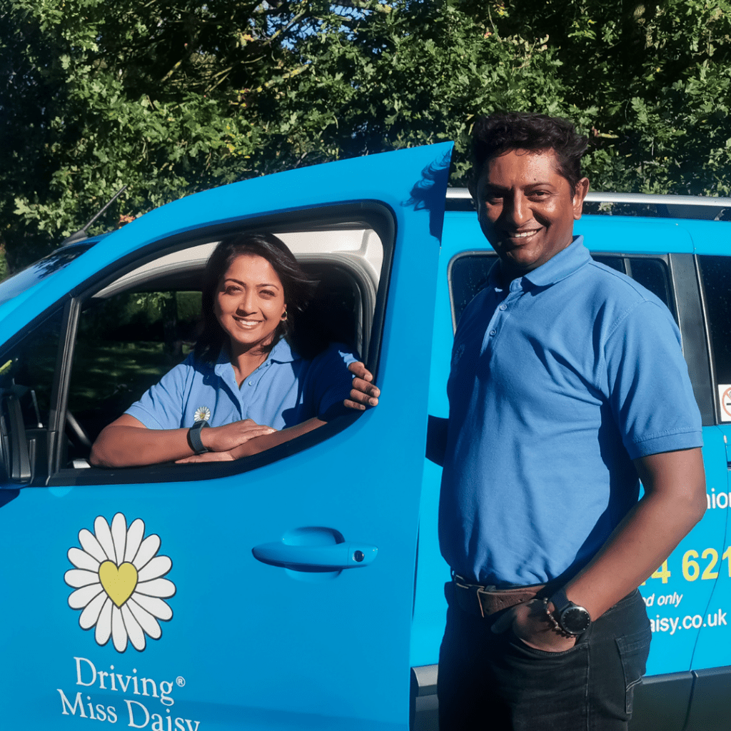 two companion drivers in Driving Miss Daisy uniform standing next to a wheelchair-accessible vehicle.