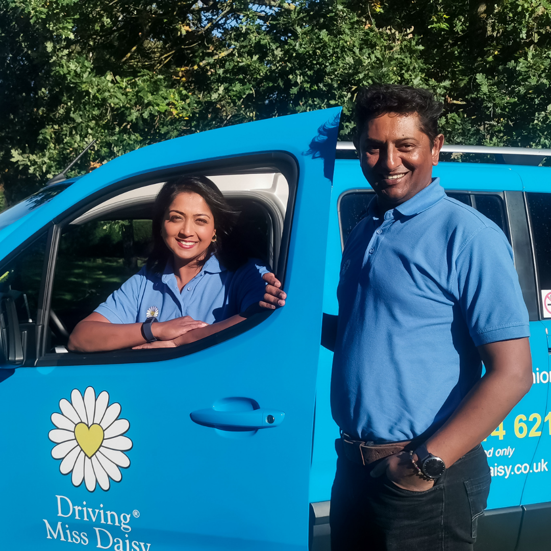 two companion drivers in Driving Miss Daisy uniform standing next to a wheelchair-accessible vehicle.