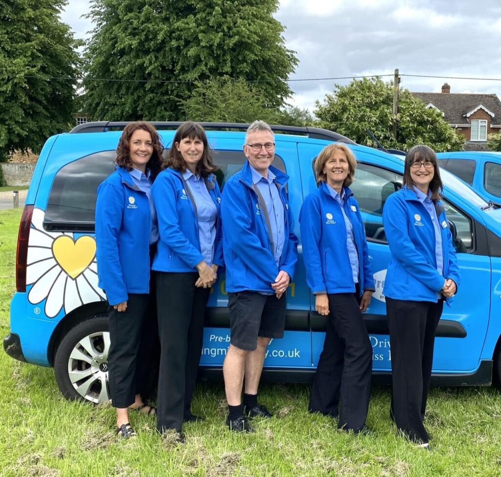 5 companion drivers in Driving Miss Daisy uniform standing in from of a wheelchair accessible vehicle