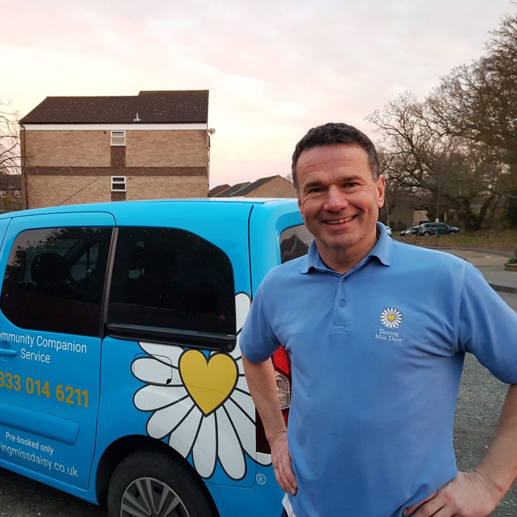 A companion Driver in Driving Miss Daisy uniform standing in front of a wheelchair accessible vehicle