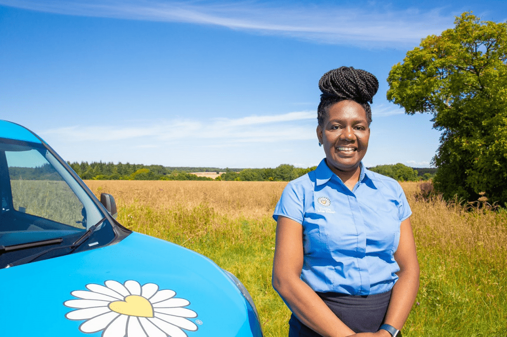 a companion driver in Driving Miss daisy uniform standing next to a wheelchair accessible vehicle.