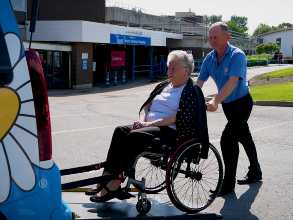 Patient Transport. A patient being pushed into the back of a wheelchair accessible vehicle.