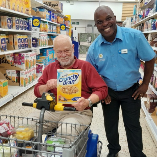 Website_NHS_500x500 A companion driver in driving miss daisy uniform taking a client shopping for essential groceries
