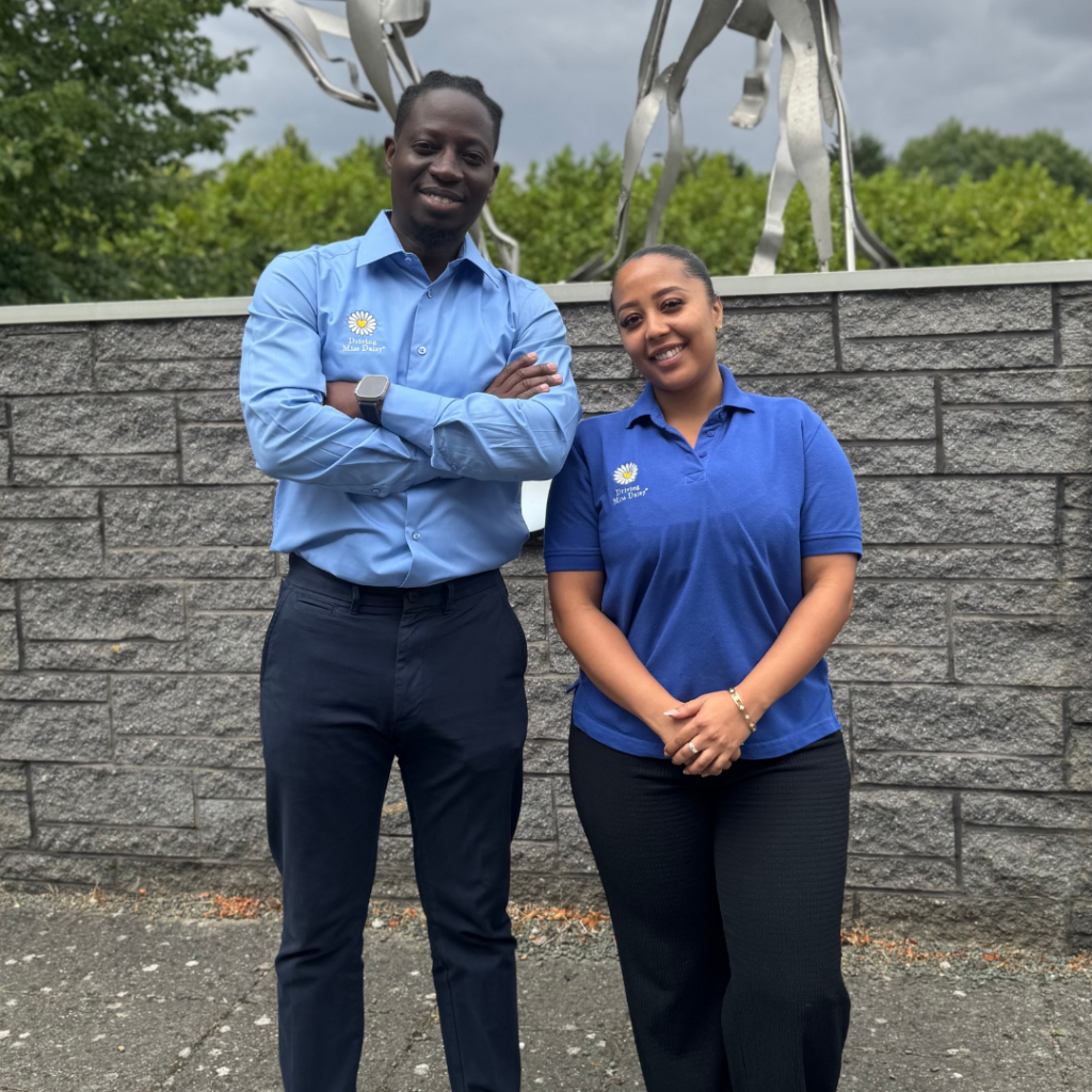 A man and woman from Driving Miss Daisy Milton Keynes East, wearing a blue uniform standing side by side.