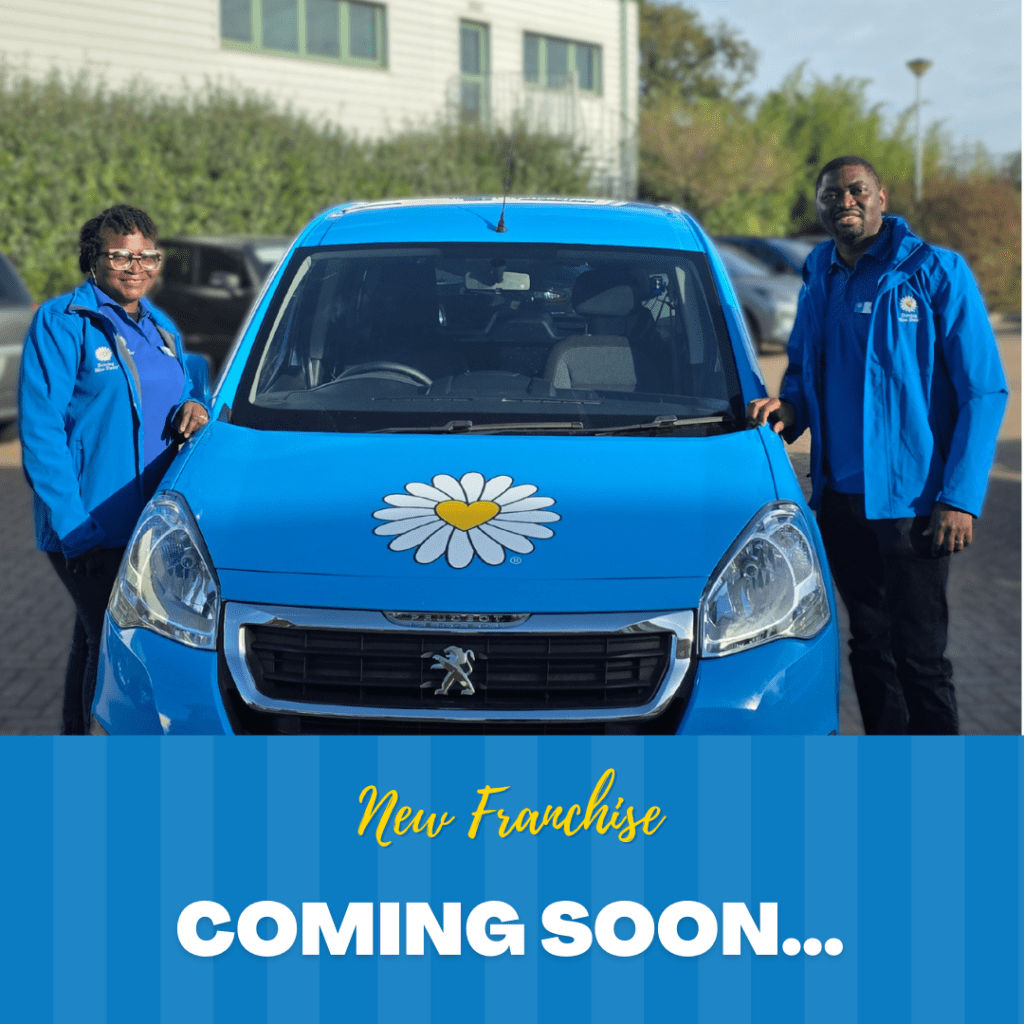 two companion drivers standing next to a blue wheelchair accessible vehicle.